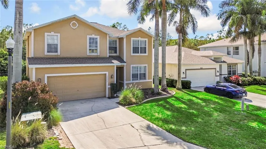 Traditional-style house with stucco siding, concrete driveway, roof with shingles, and a front yard