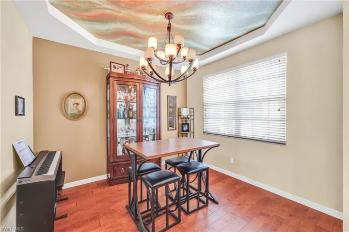 Dining area featuring a tray ceiling, hardwood / wood-style flooring, and a chandelier