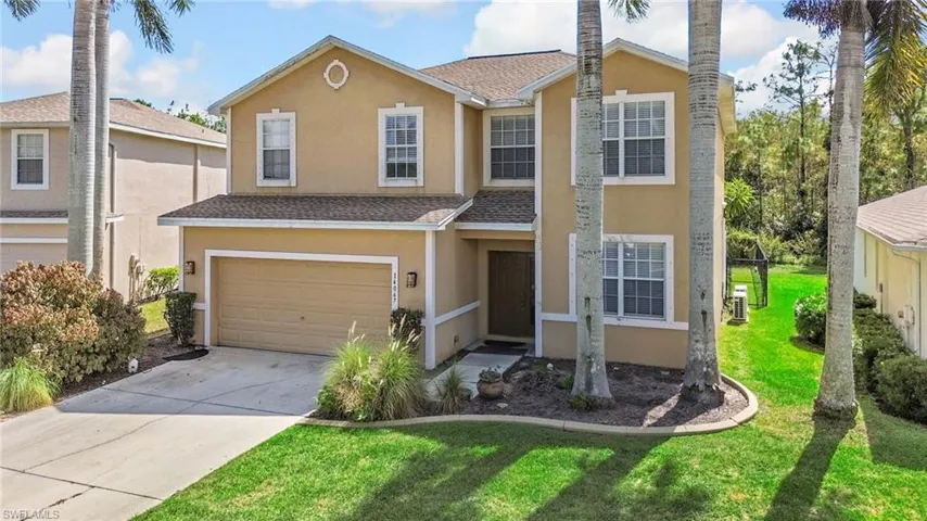 Traditional-style home featuring stucco siding, roof with shingles, concrete driveway, a front lawn, and a garage