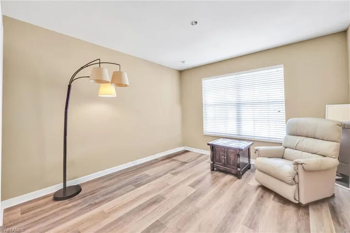 Sitting room with baseboards and light wood-style flooring