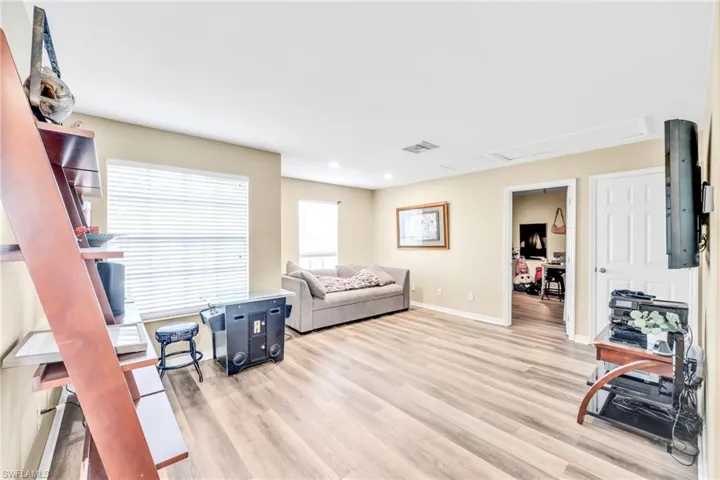 Living area with light wood-style floors and recessed lighting