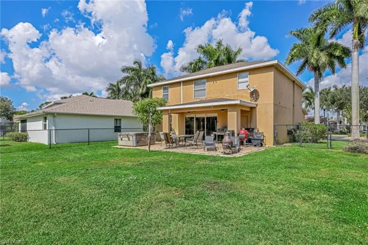 Back of house with a fenced backyard, a patio area, and stucco siding
