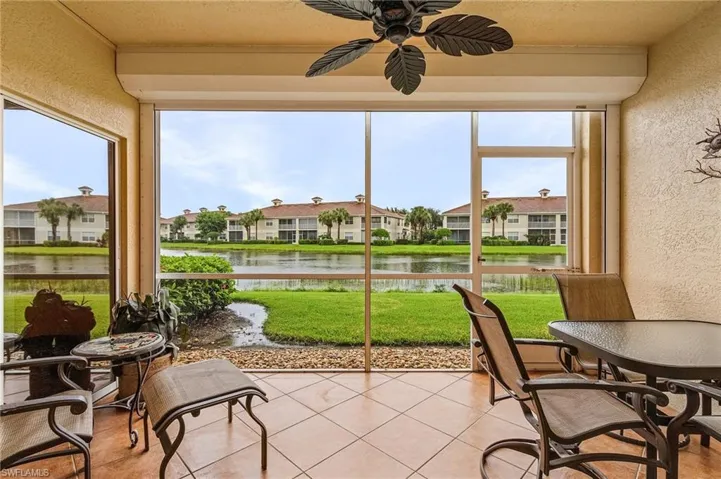 Sunroom with ceiling fan and a water view