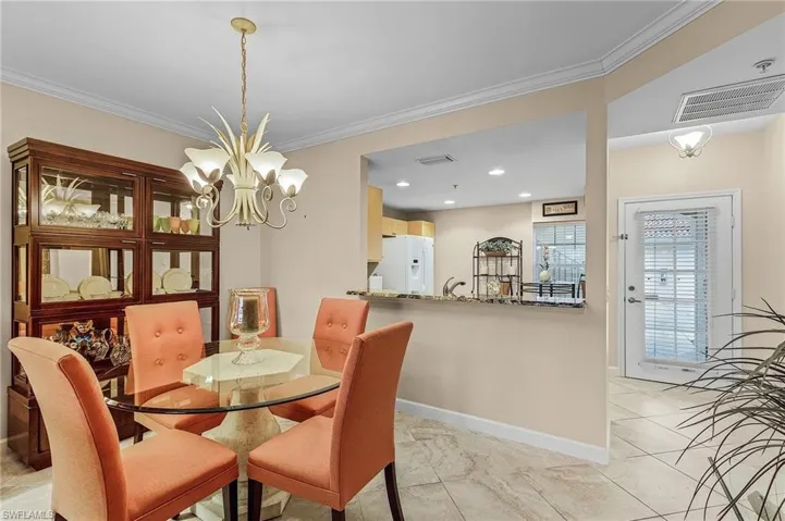 Dining area with crown molding and a notable chandelier