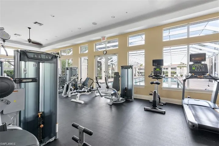 Exercise room featuring ceiling fan and french doors