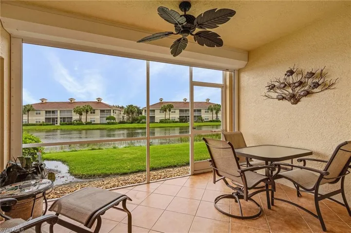 Sunroom with ceiling fan and a water view