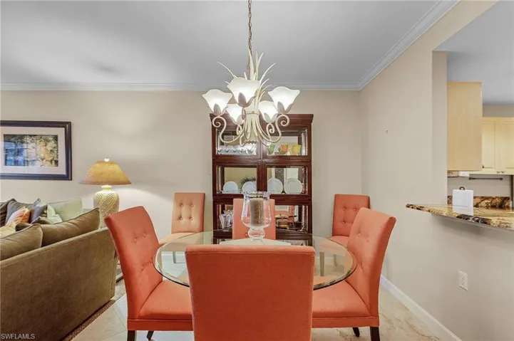 Dining area featuring ornamental molding, light tile patterned floors, and a chandelier