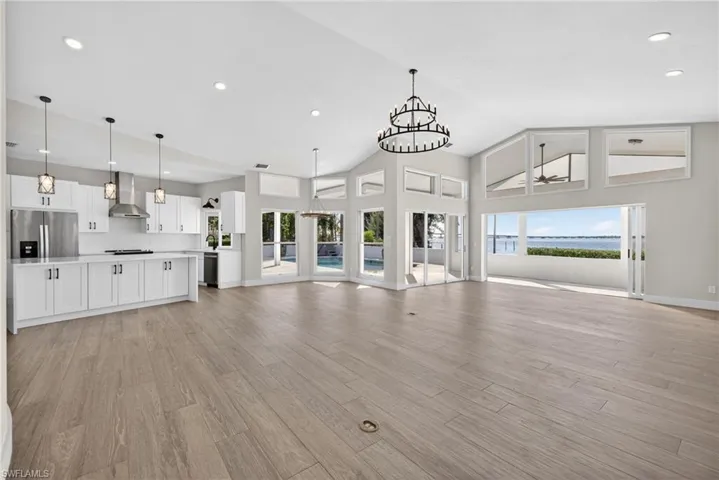 Unfurnished living room with a chandelier, a high ceiling, and light wood finished floors