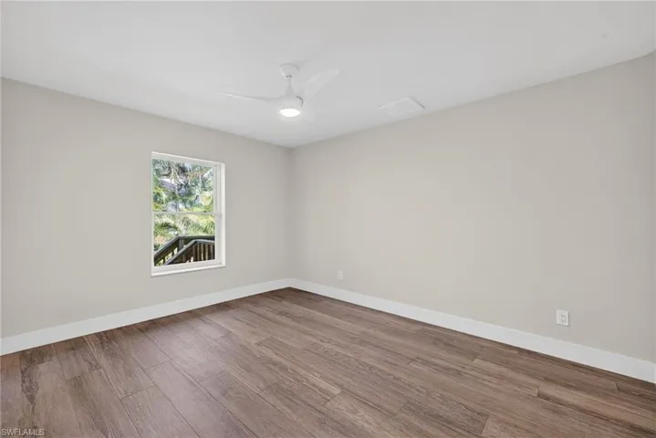 Spare room with wood finished floors and ceiling fan