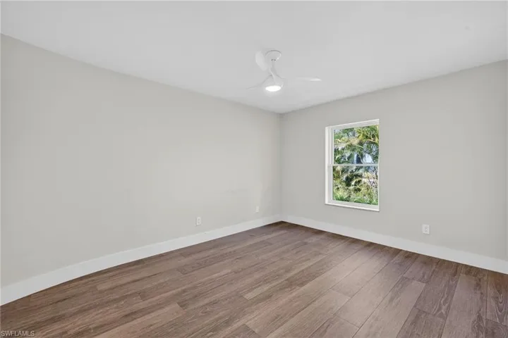 Unfurnished room with wood finished floors and a ceiling fan
