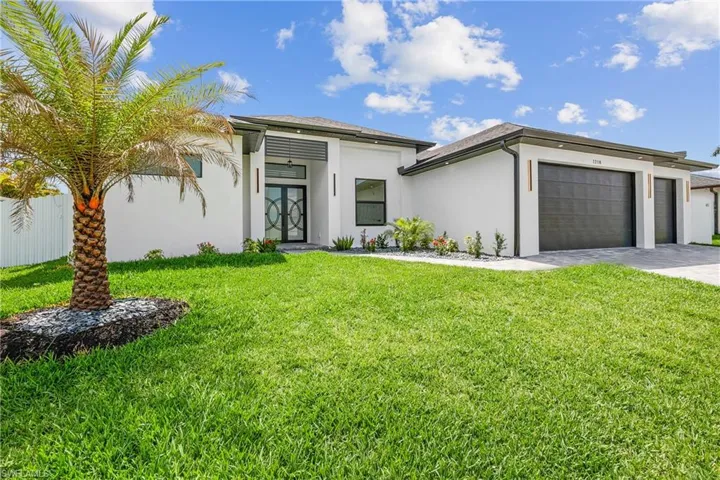 View of front of house with a garage and a front yard