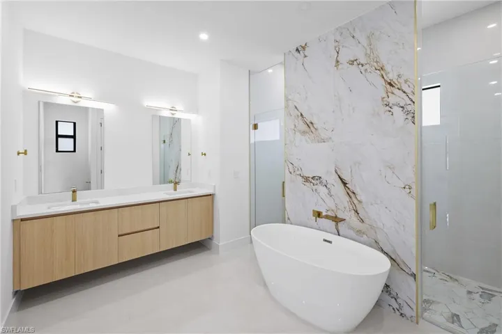Bathroom with tile floors, plenty of natural light, shower with separate bathtub, and dual bowl vanity