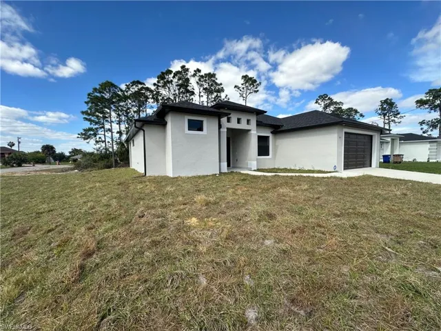 View of front of home featuring a front lawn and a garage