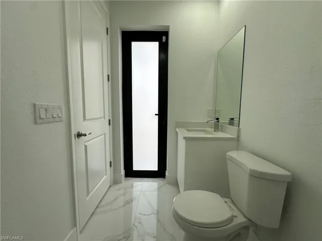 Bathroom with tile flooring, vanity, and toilet