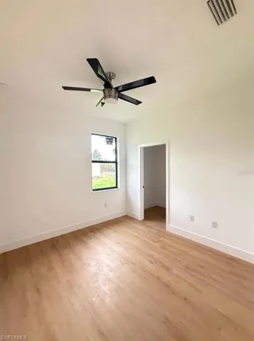 Unfurnished bedroom with light wood-type flooring, a ceiling fan, and a walk in closet