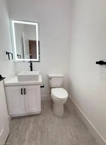 Half bath with vanity and baseboards