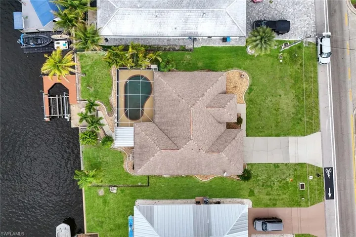 Waterfront property featuring a private boat dock with lift, an in-ground heated swimming pool with screened enclosure