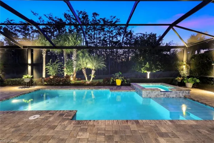 View of swimming pool featuring a lanai, a pool with connected hot tub, a sunroom, and a patio area