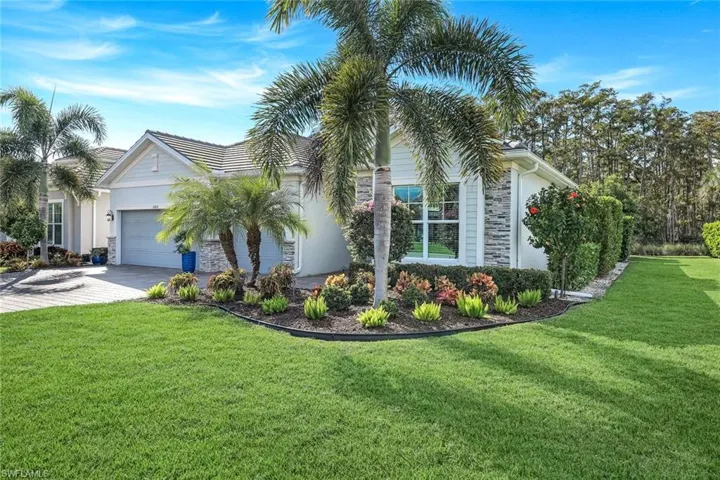 View of front of house featuring a front lawn, a garage, driveway, and stucco siding