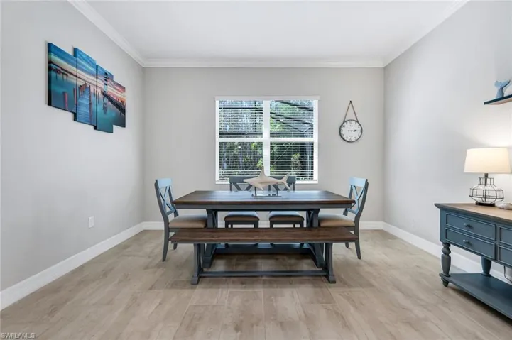Dining space with light wood finished floors and crown molding