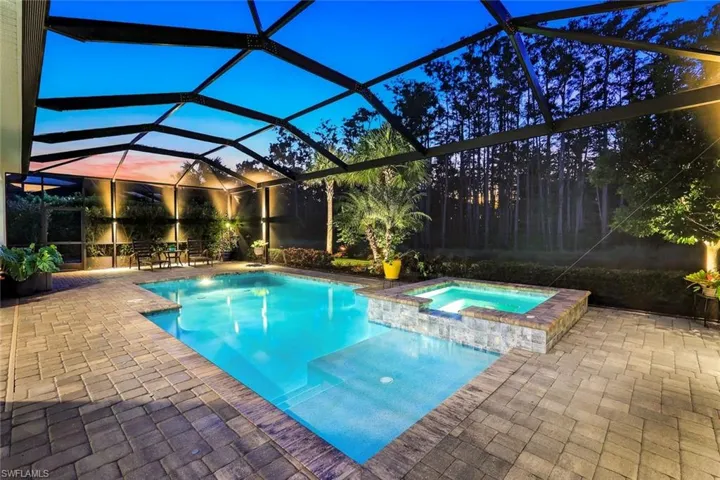 View of pool with enclosure, a patio area, a sunroom, and a pool with connected hot tub