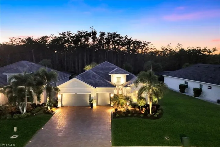 View of front of home featuring a garage, decorative driveway, and a lawn
