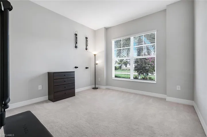 Unfurnished bedroom with light carpet and baseboards