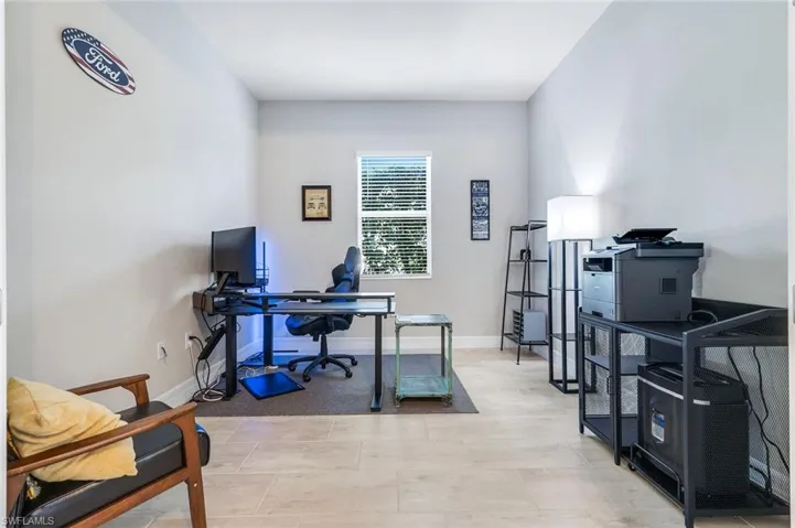 Office area with baseboards and light tile patterned flooring