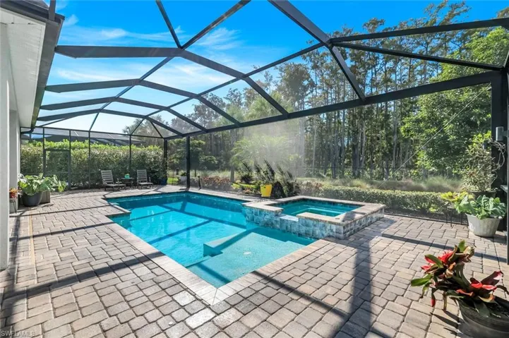 View of swimming pool featuring a lanai, a sunroom, a patio, and a pool with connected hot tub