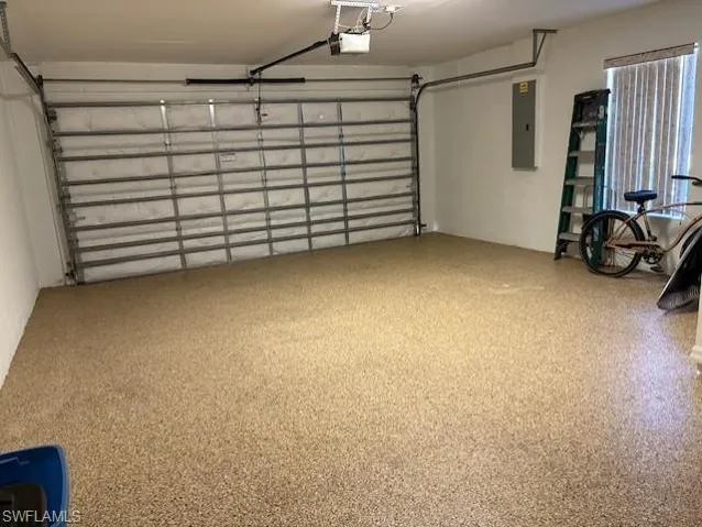 Garage featuring electric panel and a garage door opener