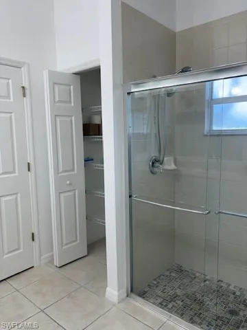 Full bath featuring a shower stall and tile patterned floors