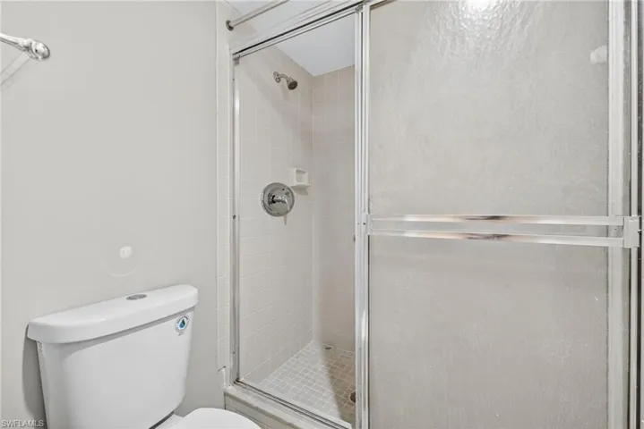 Full bath featuring a shower stall and toilet