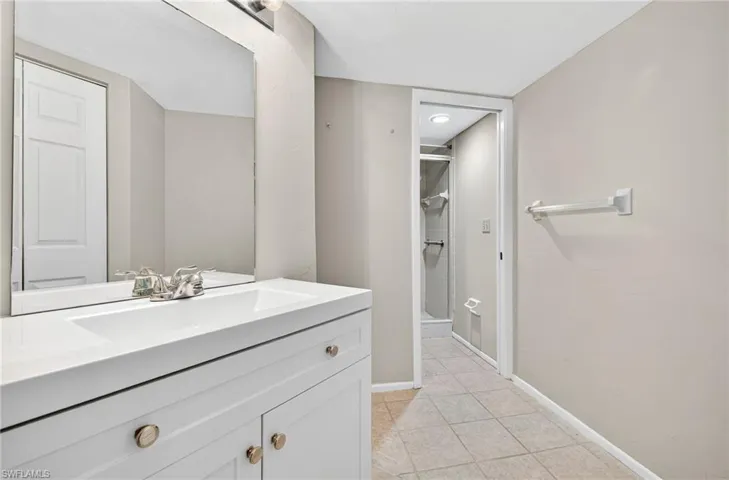 Full bathroom featuring a stall shower, vanity, and light tile patterned flooring