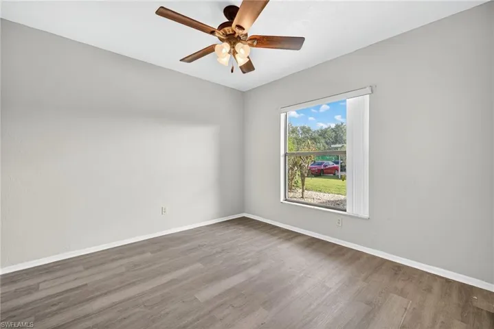 Spare room with wood finished floors and ceiling fan