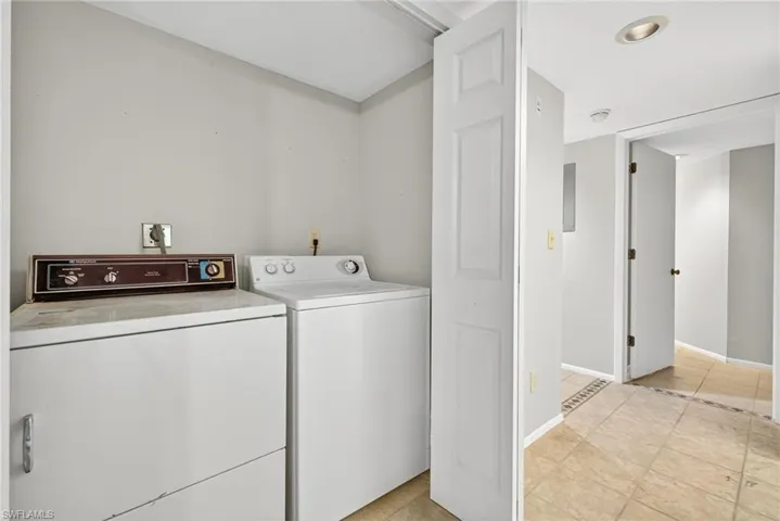 Laundry area featuring light tile patterned flooring and separate washer and dryer