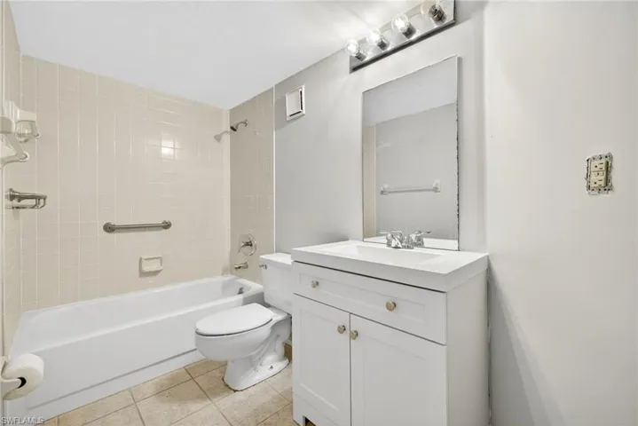 Full bath featuring bathtub / shower combination, vanity, and light tile patterned flooring