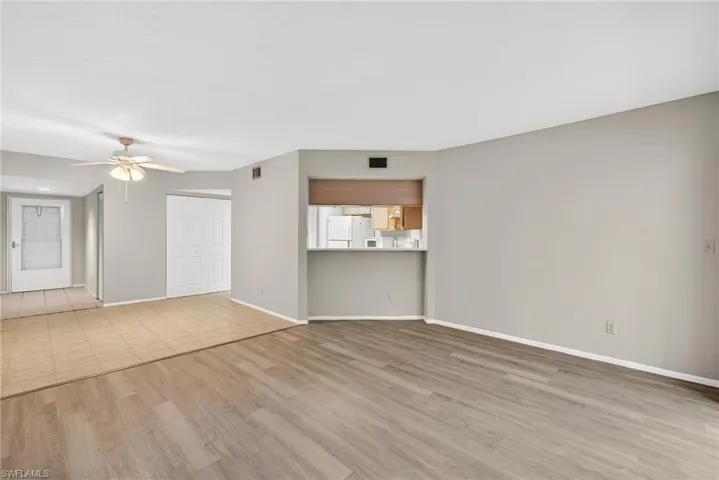Unfurnished living room featuring light wood-type flooring and ceiling fan