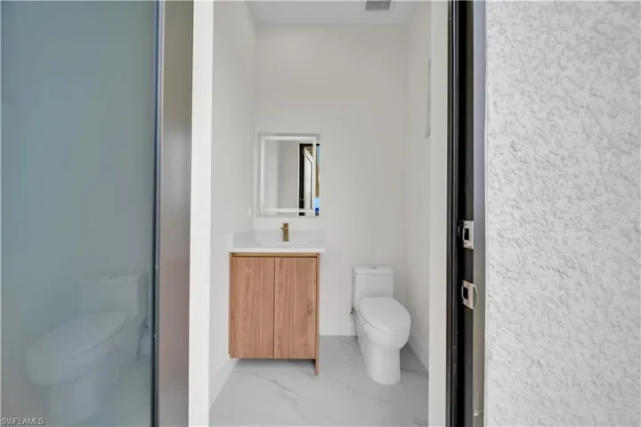Bathroom with vanity and marble finish flooring