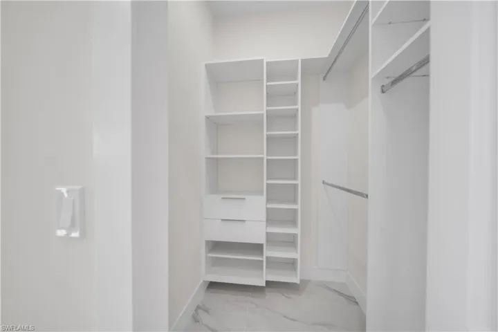 Spacious closet with light marble finish flooring