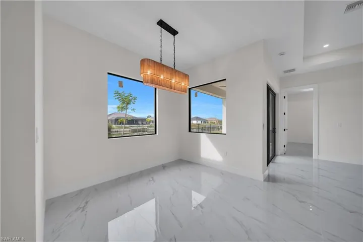 Empty room featuring marble tiled flooring and recessed lighting
