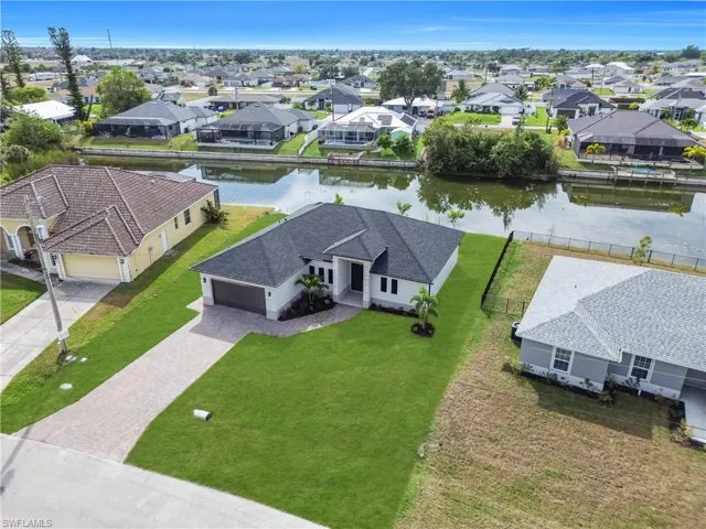 Aerial view of residential area featuring a nearby body of water