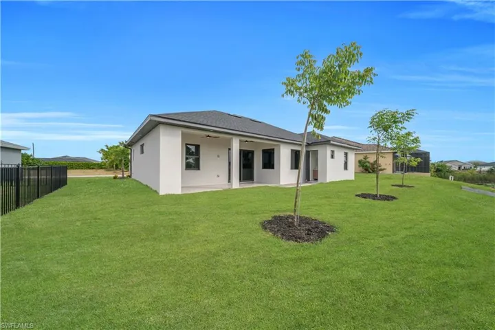 Back of house with a ceiling fan, a patio area, and stucco siding