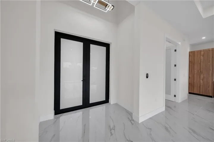 Foyer entrance featuring light marble finish floors and recessed lighting
