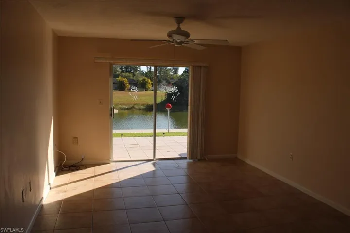 Spare room featuring ceiling fan, a water view, and light tile patterned floors