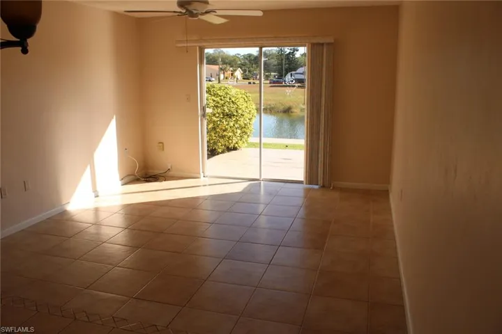 Spare room with tile patterned flooring, ceiling fan, and a water view
