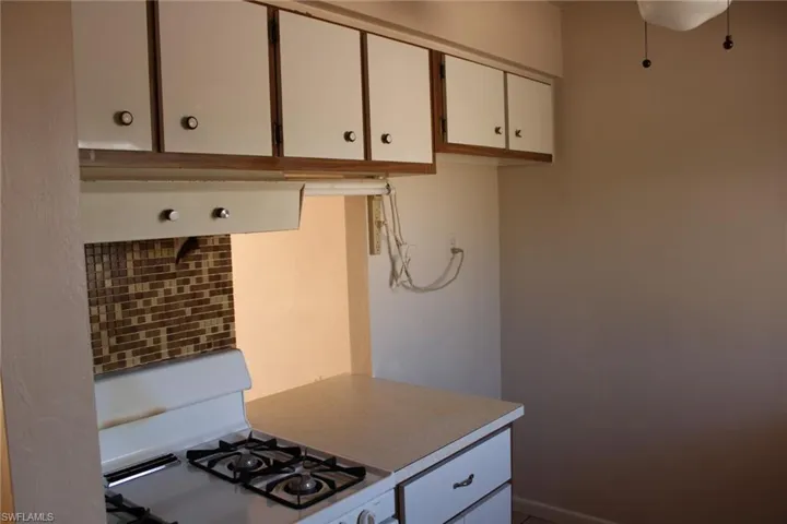 Kitchen featuring white gas range oven and white cabinetry