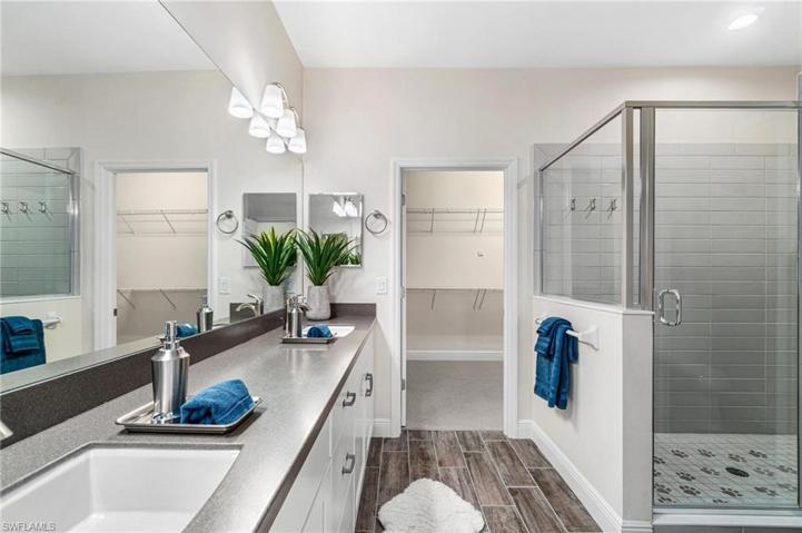 Primary bathroom offering a spacious walk-in closet and shower.