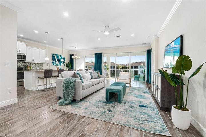 This open floor plan offers a bright and spacious living and kitchen area.  Volume ceilings with crown molding and wood-like tile flooring, plenty of natural light, along with a cool color palette add to the airy feel of this home.