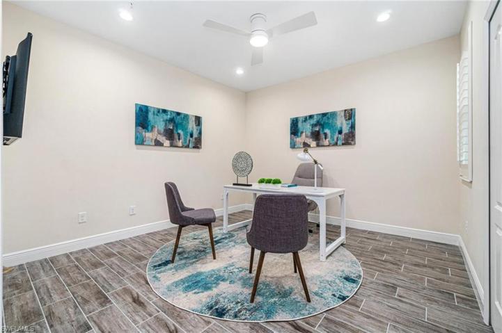 Second Bedroom that we have staged as an executive office, adorned with plantation shutters and wood-like tile floors.
