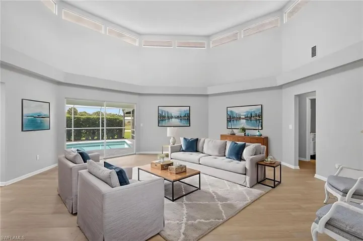 Spacious living area featuring light wood-finish flooring and high volume ceilings